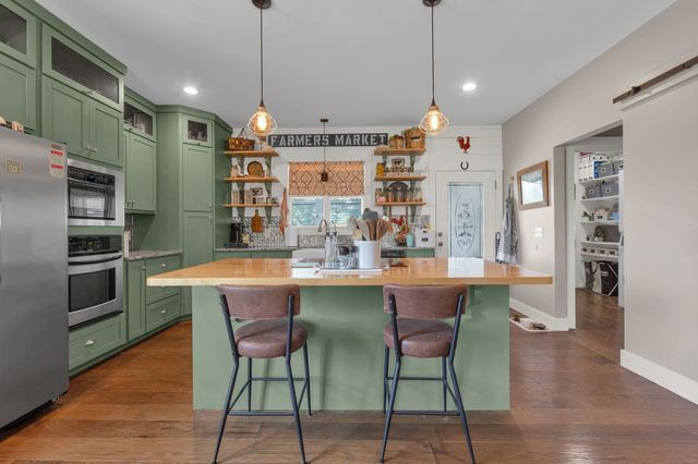 a kitchen with stainless steel appliances granite countertop a kitchen island a stove and a refrigerator