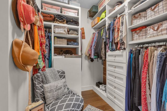 a view of walk in closet with clothes and shoes