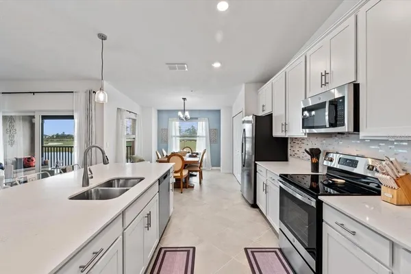 a kitchen with white cabinets sink and stainless steel appliances