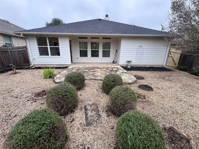 a view of a backyard with potted plants and wooden fence