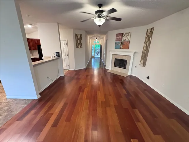 a view of a livingroom with wooden floor and a ceiling fan