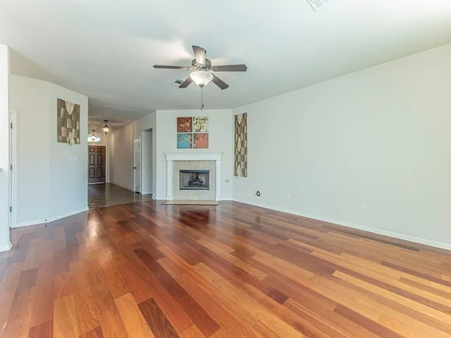 a view of empty room with wooden floor and fireplace