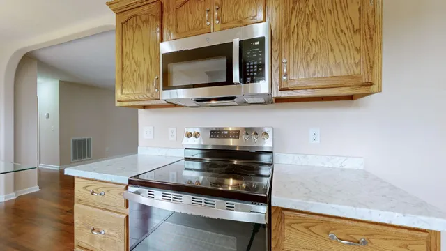 a kitchen with stainless steel appliances granite countertop a stove and a microwave