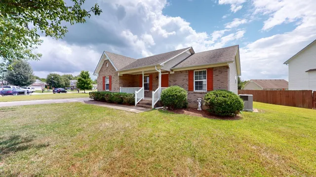 a view of a house with a yard and potted plants