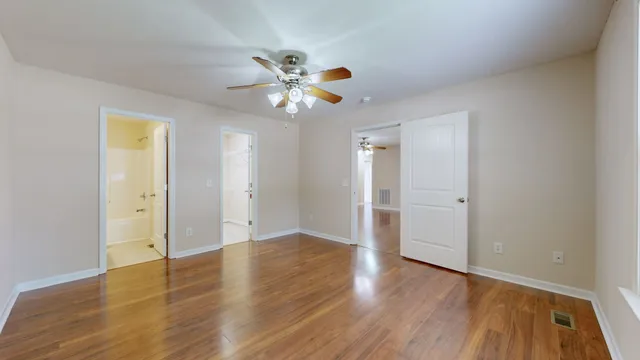 a view of an empty room with wooden floor