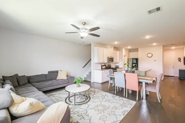 a living room with furniture kitchen view and a dining table