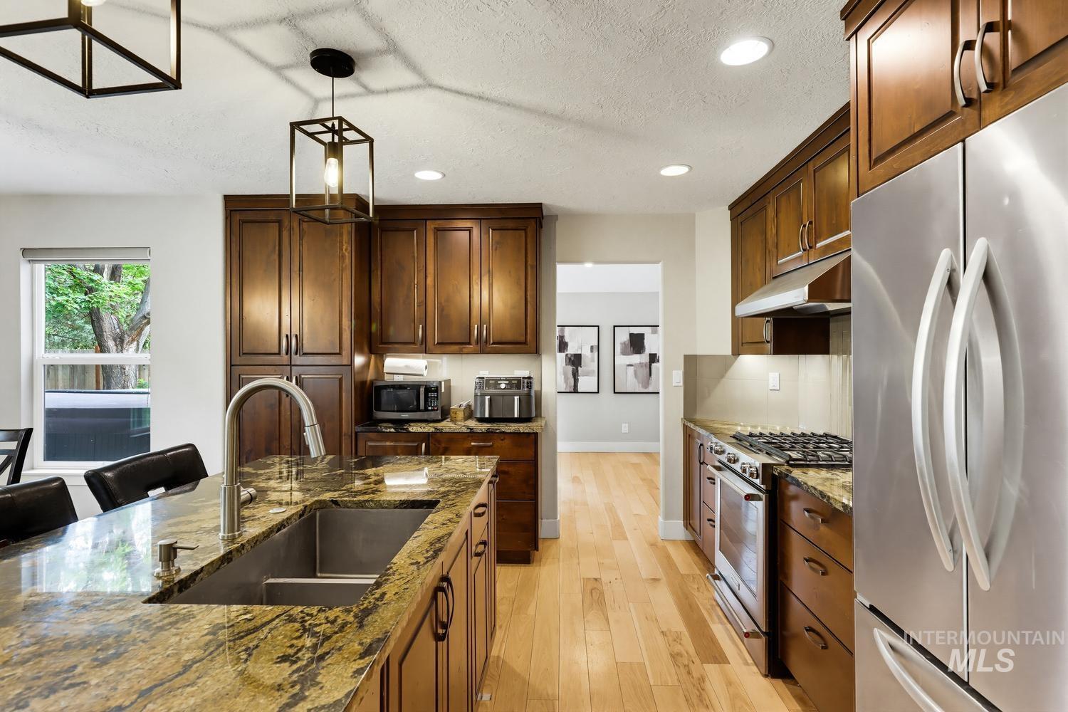 369 South Winthrop Way Boise, ID 83709 - Photo 16 of 50 Kitchen featuring a large island with an undermount sink and a gooseneck faucet