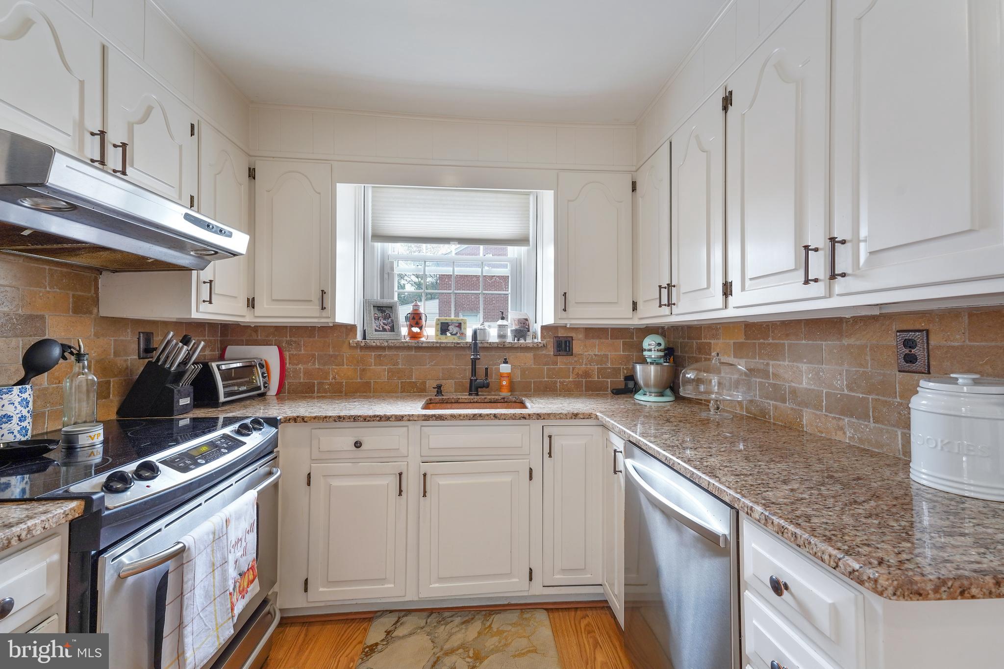 311 Avon Road Springfield, PA 19064 - Photo 12 of 38 a kitchen with stainless steel appliances granite countertop a sink stove and cabinets