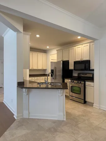 a kitchen with stainless steel appliances kitchen island granite countertop a stove top oven a sink dishwasher and a microwave oven on the blue kitchen countertops