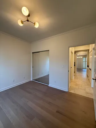 a view of a room with wooden floor and a ceiling fan