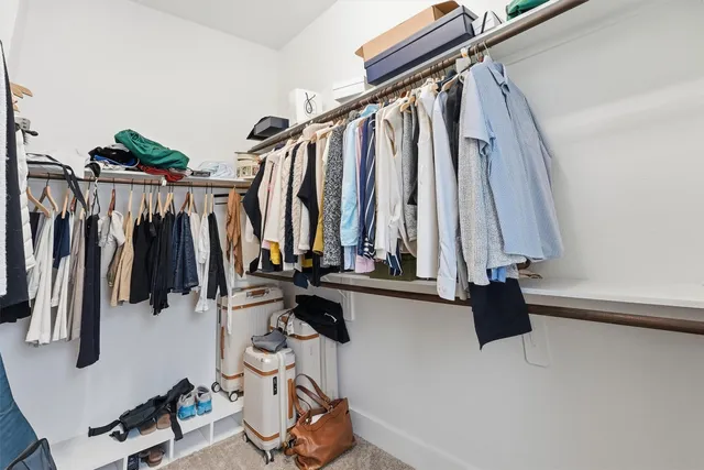 a view of walk in closet with clothes and shoes