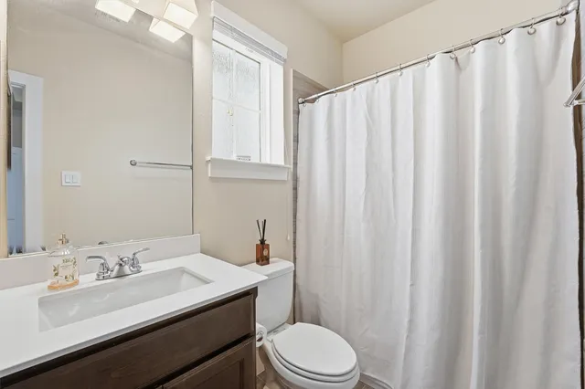 a bathroom with a sink a toilet and shower curtain