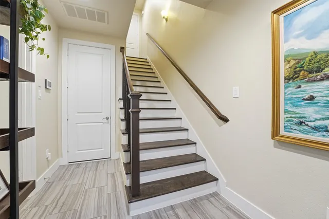 a view of a hallway with wooden floor and staircase