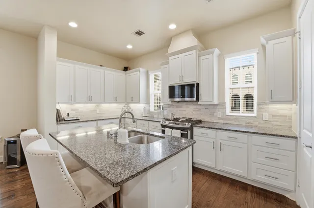 a kitchen with center island a sink stainless steel appliances and cabinets