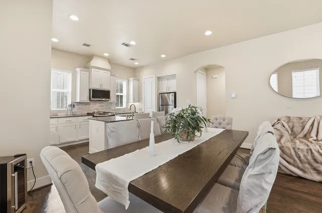 a large kitchen with cabinets chairs and white appliances