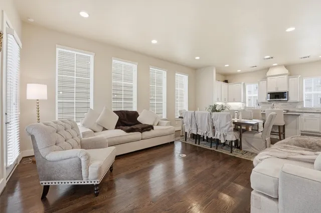 a living room with furniture wooden floor and a large window