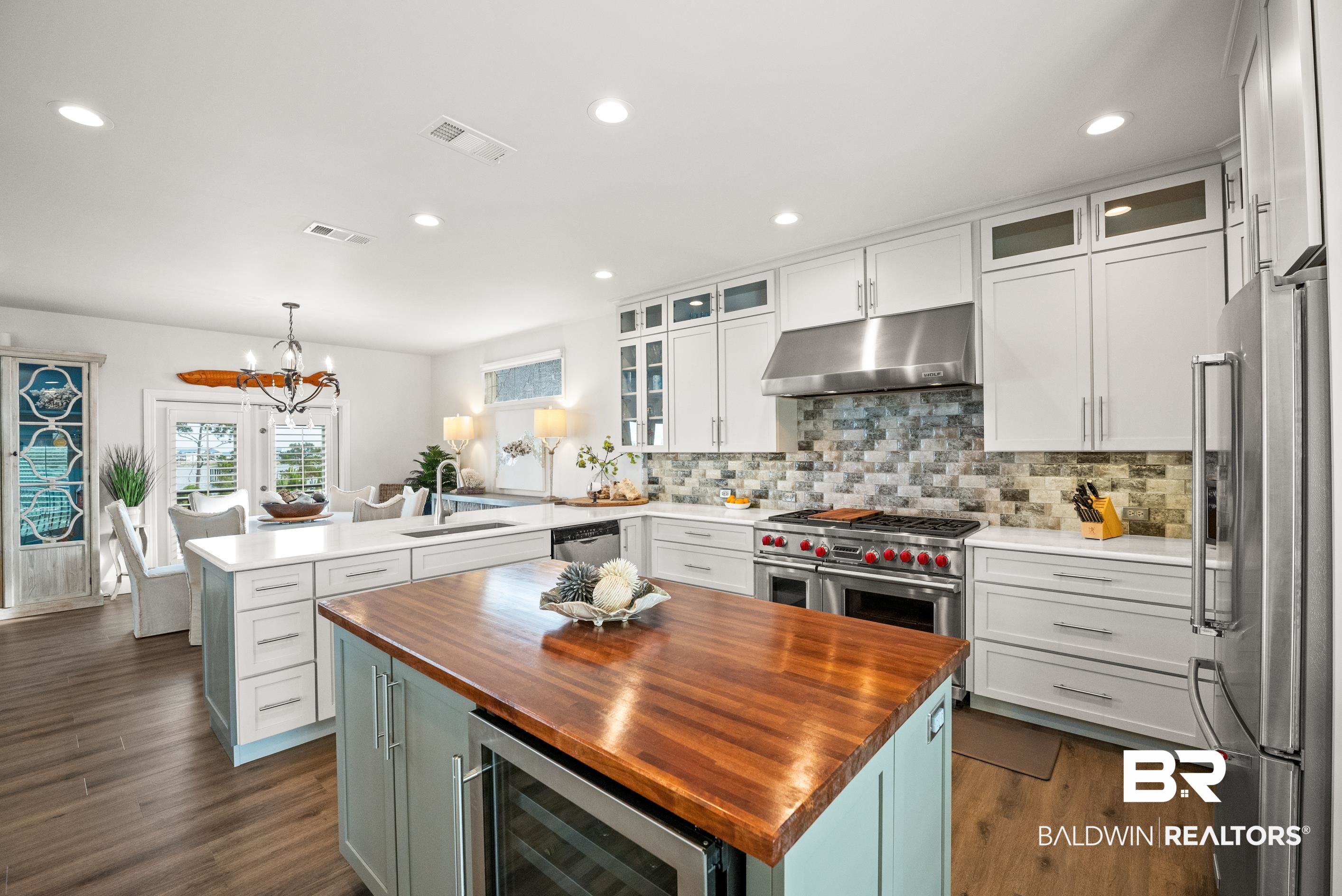 30954 River Road Orange Beach, AL 36561 - Photo 26 of 59 Kitchen featuring under cabinet range hood, wooden counters, stainless steel appliances, a sink, and recessed lighting