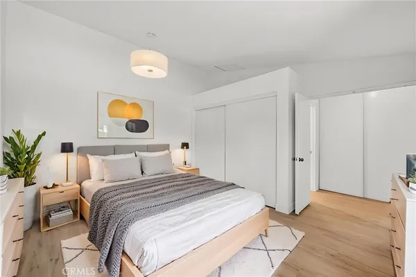 a bedroom with a bed and painting on the wall