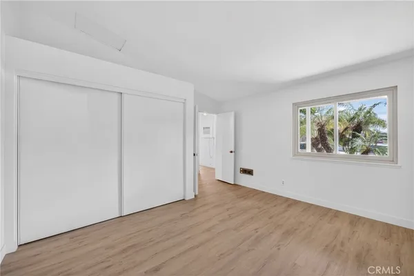 an empty room with wooden floor and window
