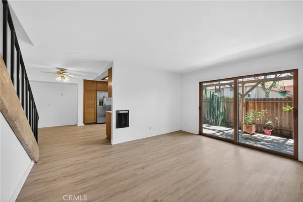 an empty room with sliding glass door and wooden floor