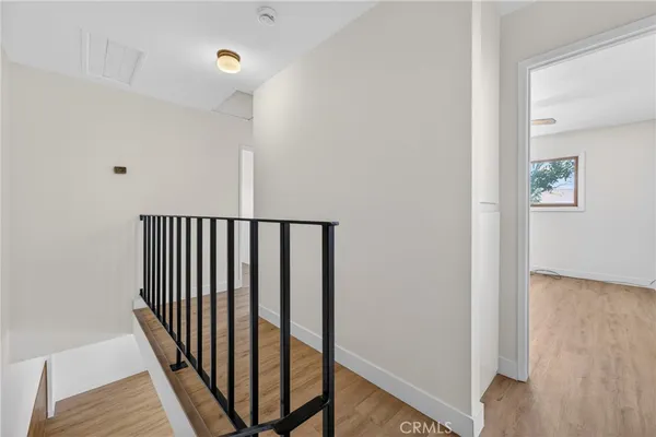 a view of a hallway with wooden floor and stairs
