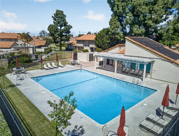 a view of a house with pool and chairs