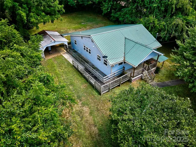 an aerial view of a house with swimming pool and garden