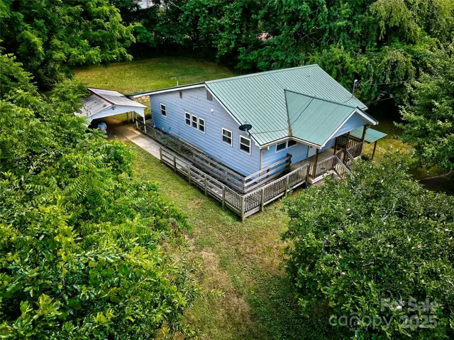 an aerial view of a house with a yard and lake view