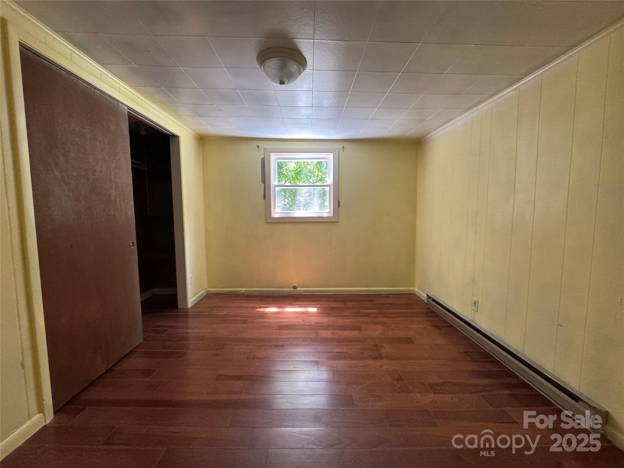 111 Kenneth Cooper Road Whittier, NC 28789 - Photo 27 of 30 an empty room with wooden floor and windows