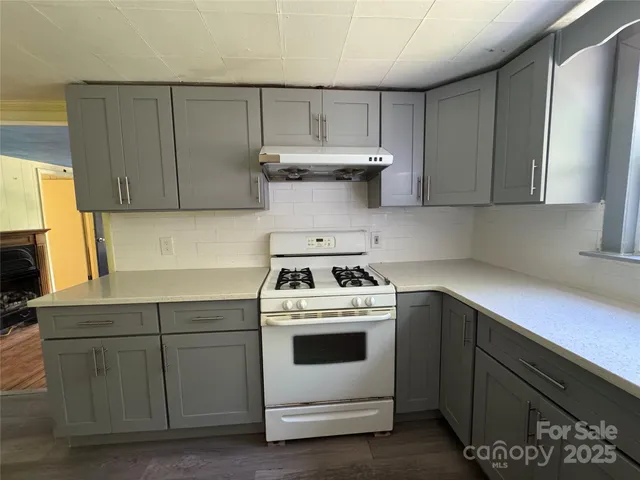 a kitchen with a stove sink and cabinets