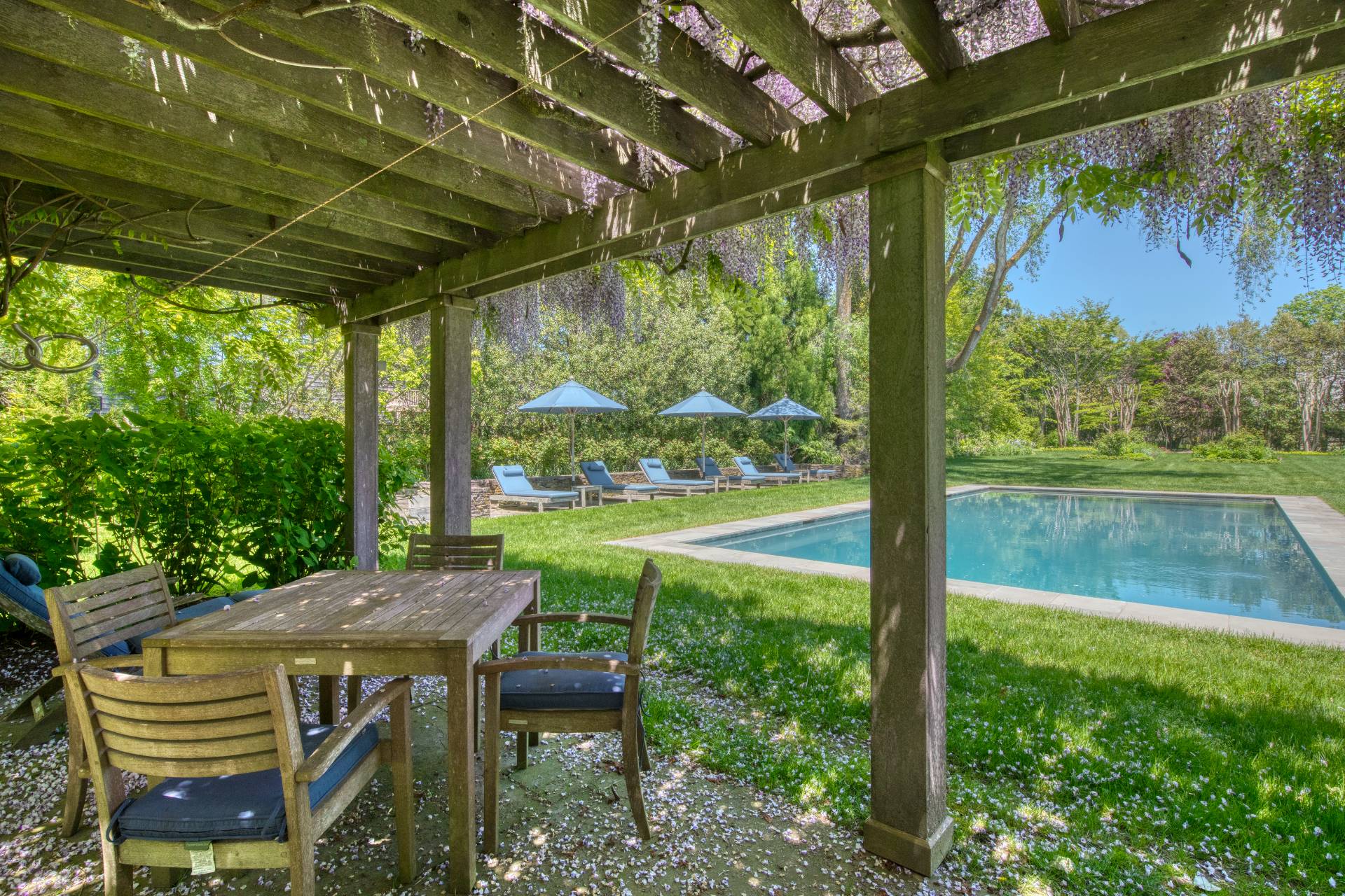 46 Westminster Road Water Mill, NY 11976 - Photo 25 of 28 a view of a patio with table and chairs under an umbrella with a small yard