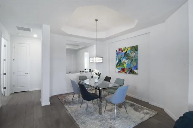 a kitchen with a refrigerator and chairs