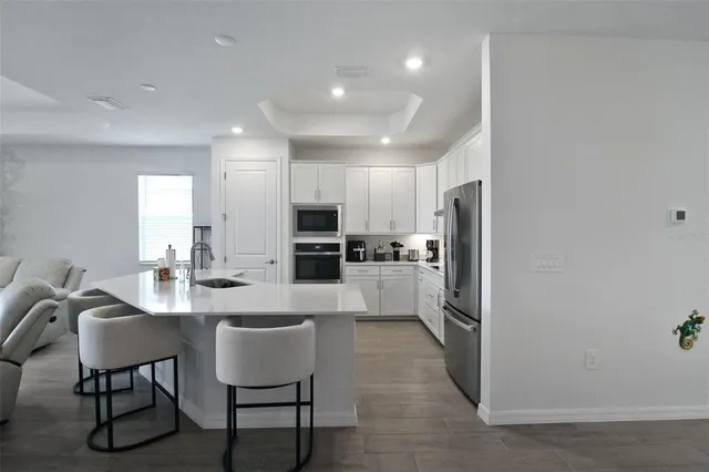 a kitchen with white cabinets and black appliances