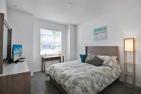 a bedroom with a bed and a flat tv screen on the dresser