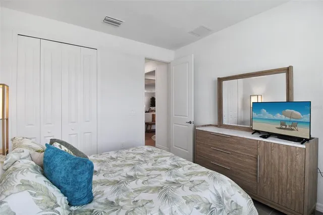 a bedroom with a bed and a flat screen tv