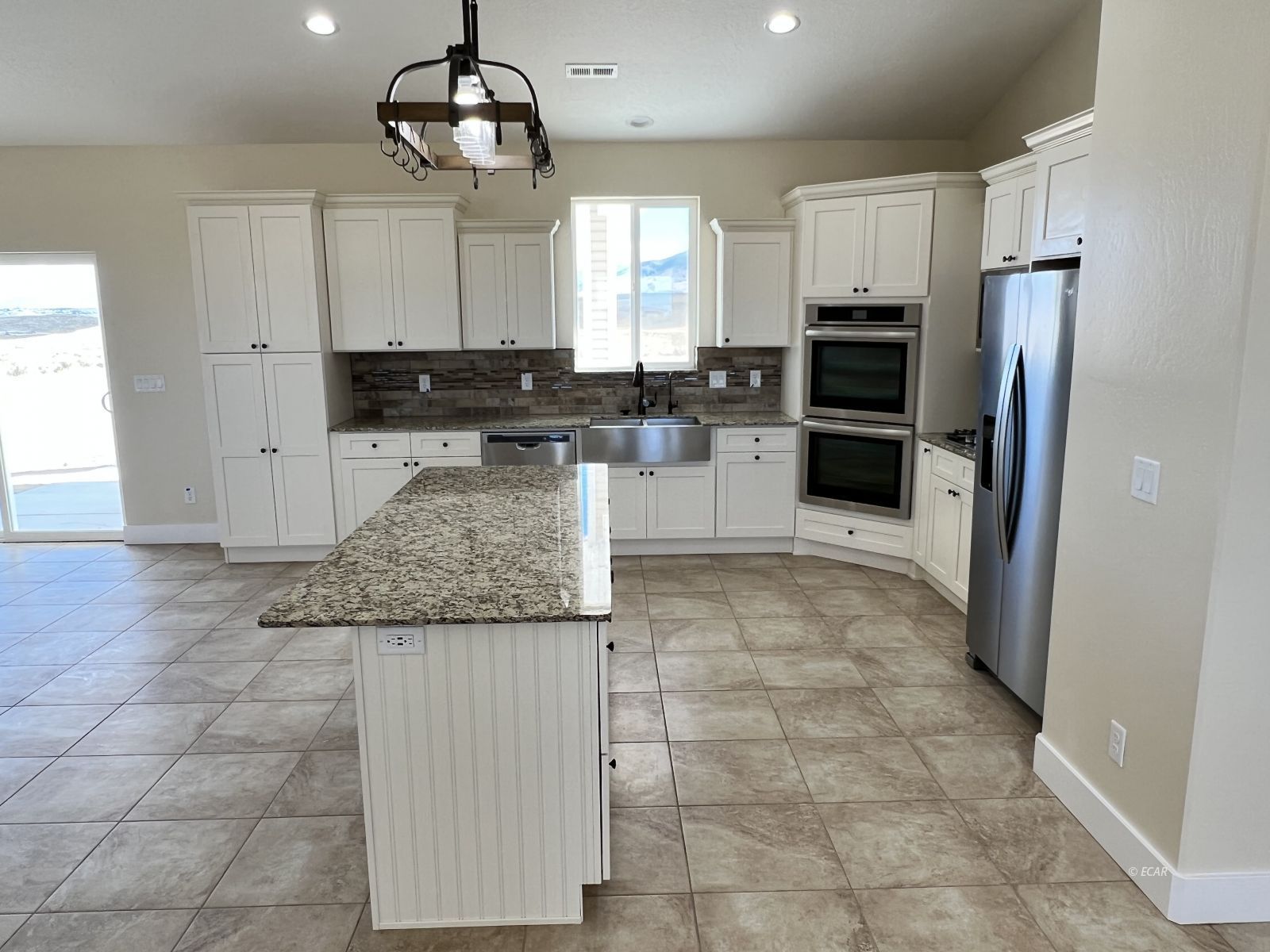 200 Ridgeway Drive Spring Creek, NV 89815 - Photo 13 of 34 a kitchen with granite countertop a refrigerator a stove a microwave and island