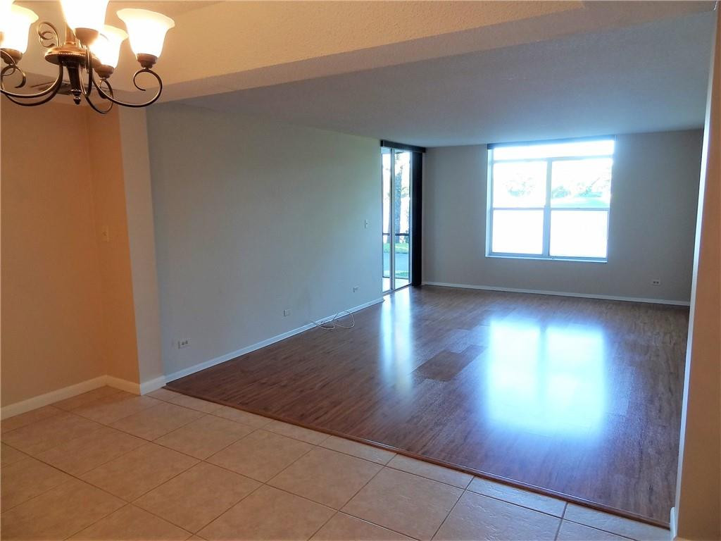 3670 Inverrary Drive, Unit 1L Lauderhill, FL 33319 - Photo 11 of 26 an empty room with wooden floor and windows