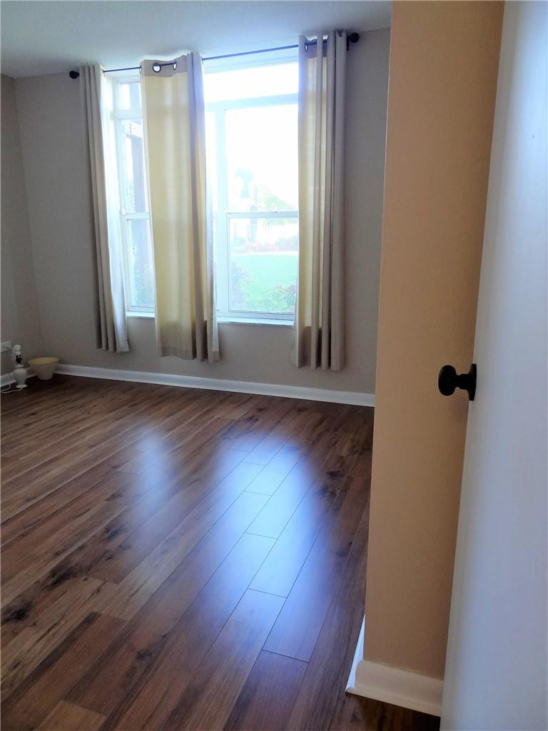 3670 Inverrary Drive, Unit 1L Lauderhill, FL 33319 - Photo 14 of 26 an empty room with wooden floor and windows