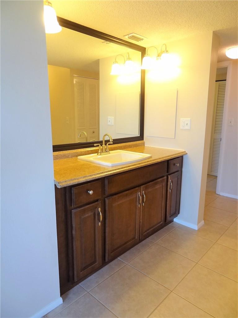 3670 Inverrary Drive, Unit 1L Lauderhill, FL 33319 - Photo 6 of 26 a bathroom with a granite countertop sink and a mirror