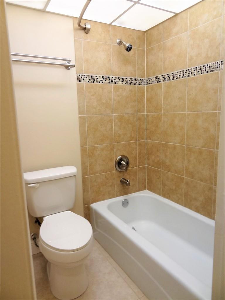 3670 Inverrary Drive, Unit 1L Lauderhill, FL 33319 - Photo 7 of 26 a white toilet sitting next to a bath tub