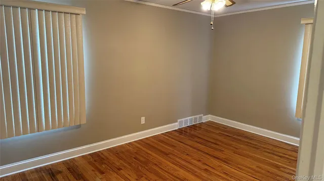 a view of a room with wooden floor and fan