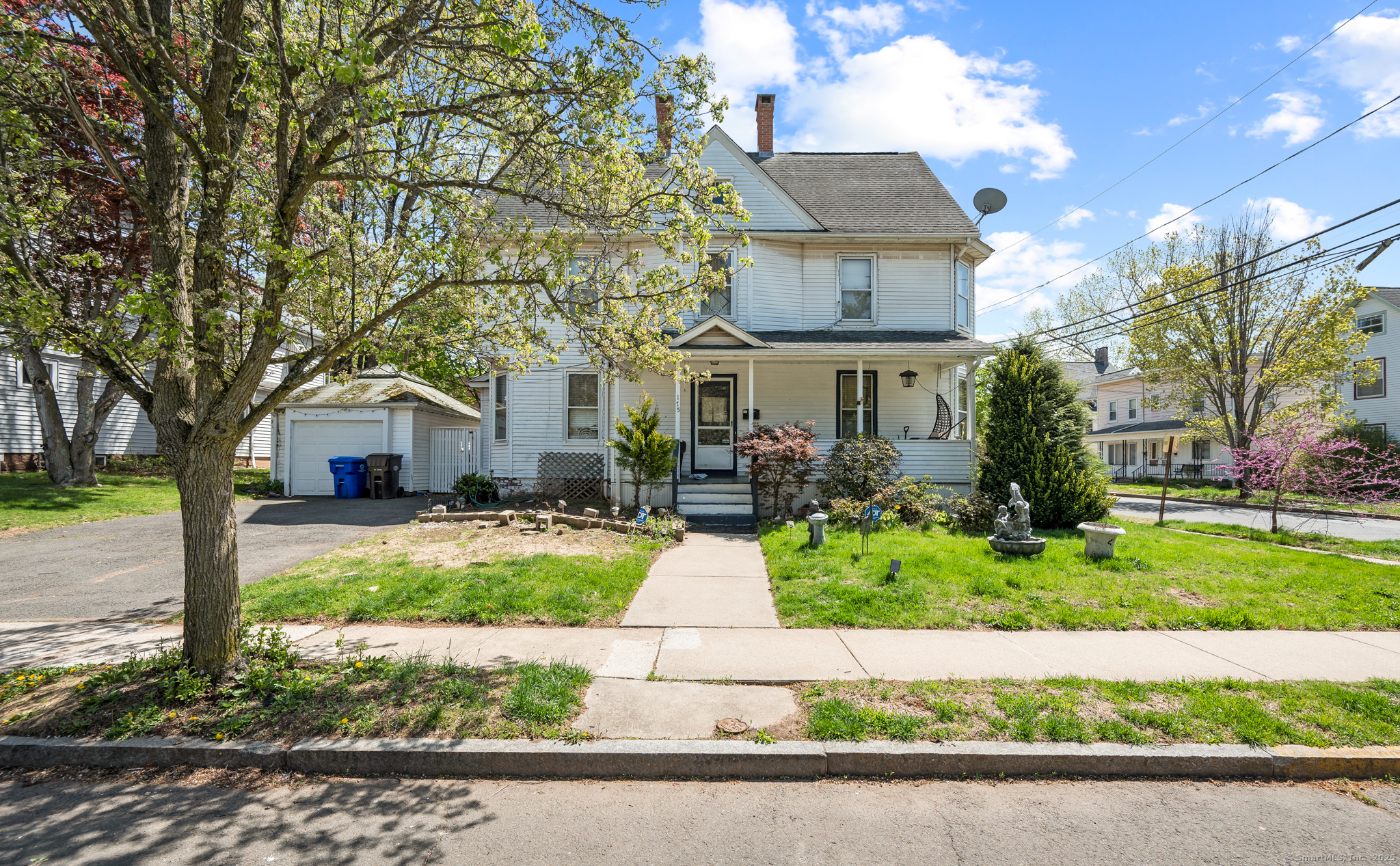 a front view of a house with a garden and trees