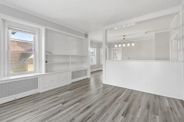 a view of a room with wooden floor and windows