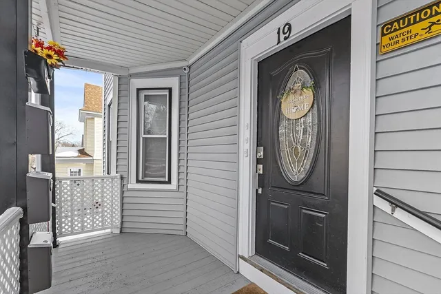 a view of a hallway with entryway wooden floor and front door