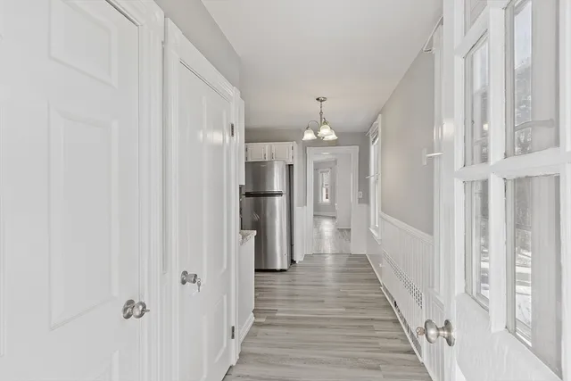 a view of a hallway with wooden floor and staircase