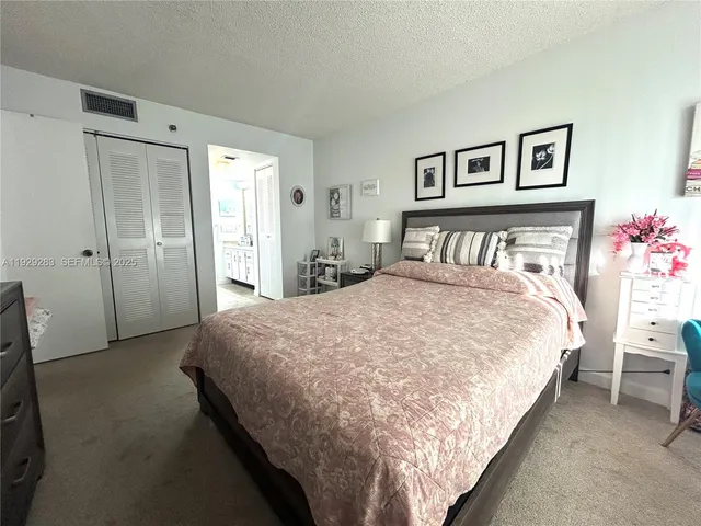 a large bed in a bedroom next to a window