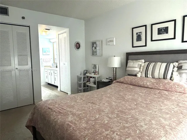 a bedroom with a bed and painting on the wall