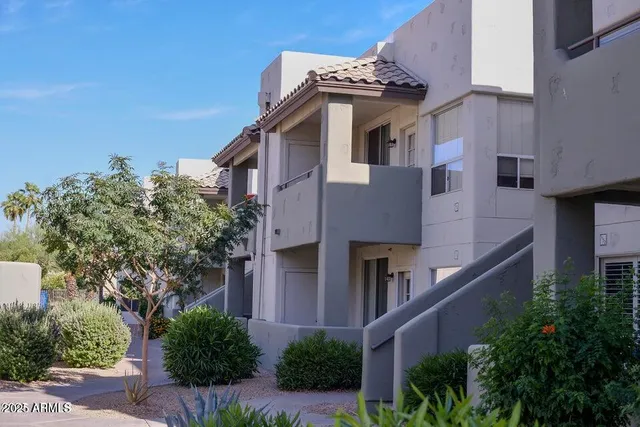 a yellow building with trees in front of it