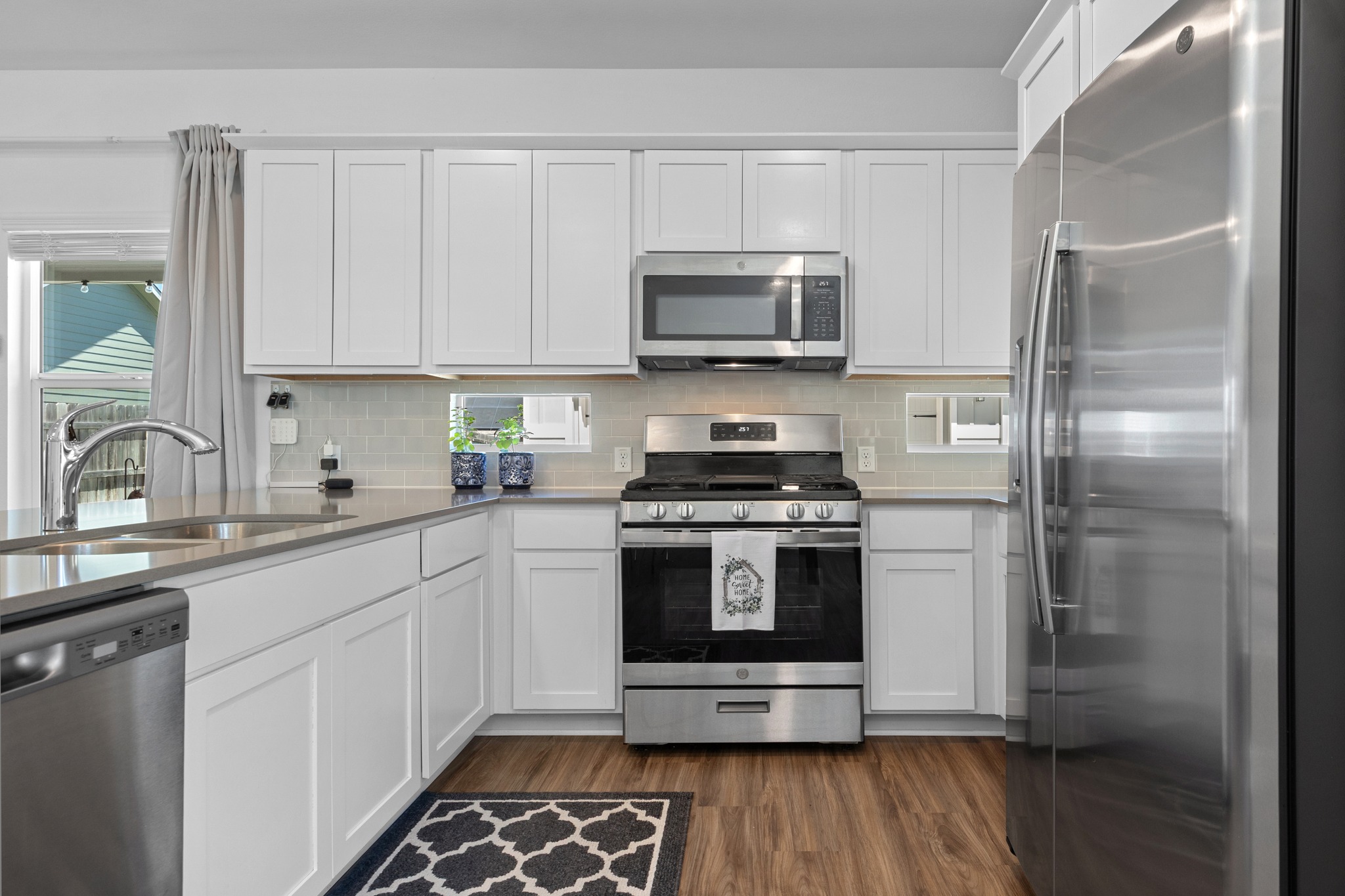 1500 Linwood Street Leander, TX 78641 - Photo 11 of 38 a kitchen with stainless steel appliances a stove a sink and a microwave