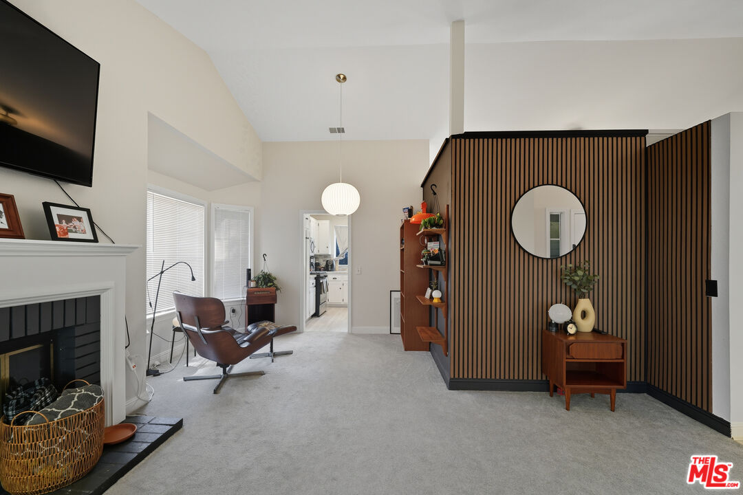 2048 East Ave R 10 Palmdale, CA 93550 - Photo 11 of 45 a living room with furniture a flat screen tv and a fireplace